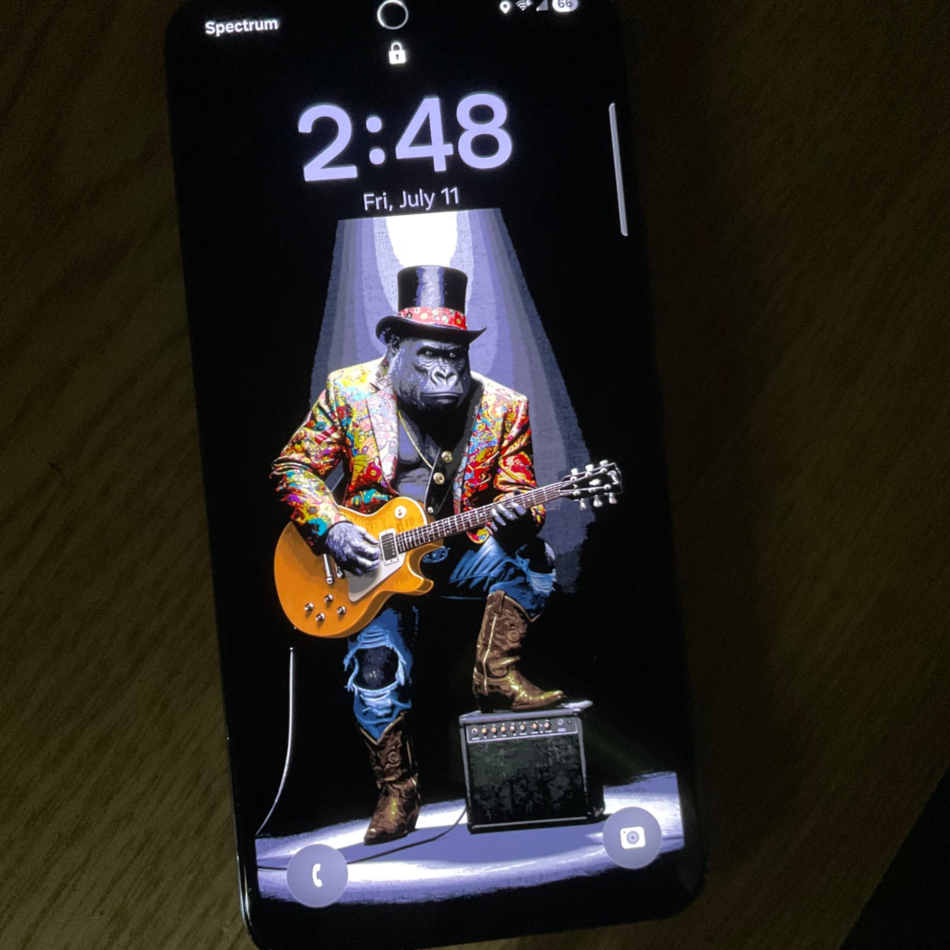 Phone screen displaying an image of a gorilla playing guitar with a colorful jacket and hat.